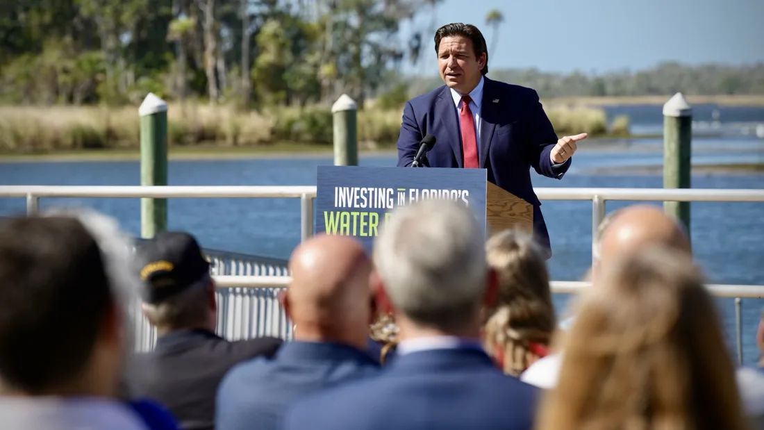 Gov. Ron DeSantis speaks at a podium reading "Investing in Florida's Water" on a waterfront dock in Crystal River as an audience listens, Oct. 28, 2026.
